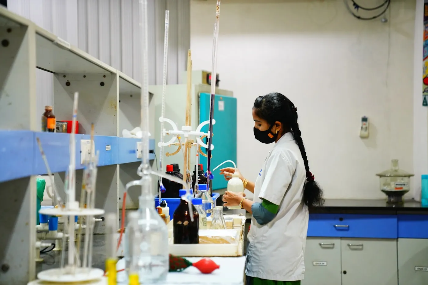 A researcher in protective gear working in a laboratory in India